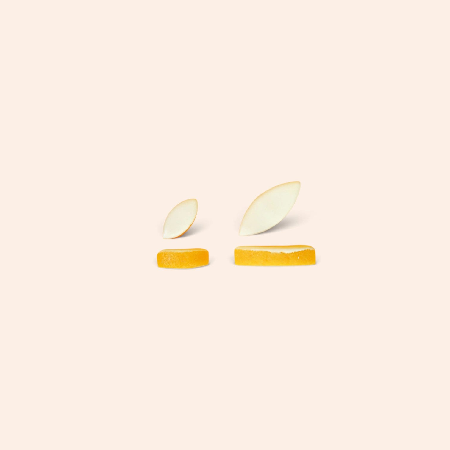 Tranches d'orange confite et pétales d'amande pour les calissons Maison Fruidoraix sur fond beige clair