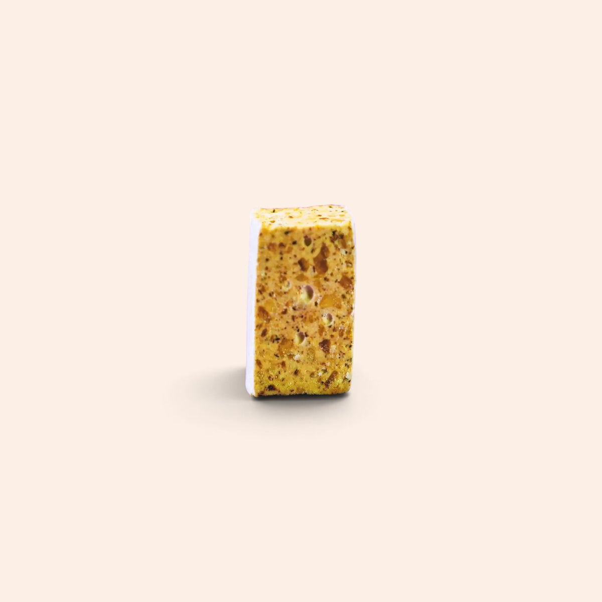Morceau de nougat aux noisettes Maison Fruidoraix à la texture tendre et croquante sur fond beige