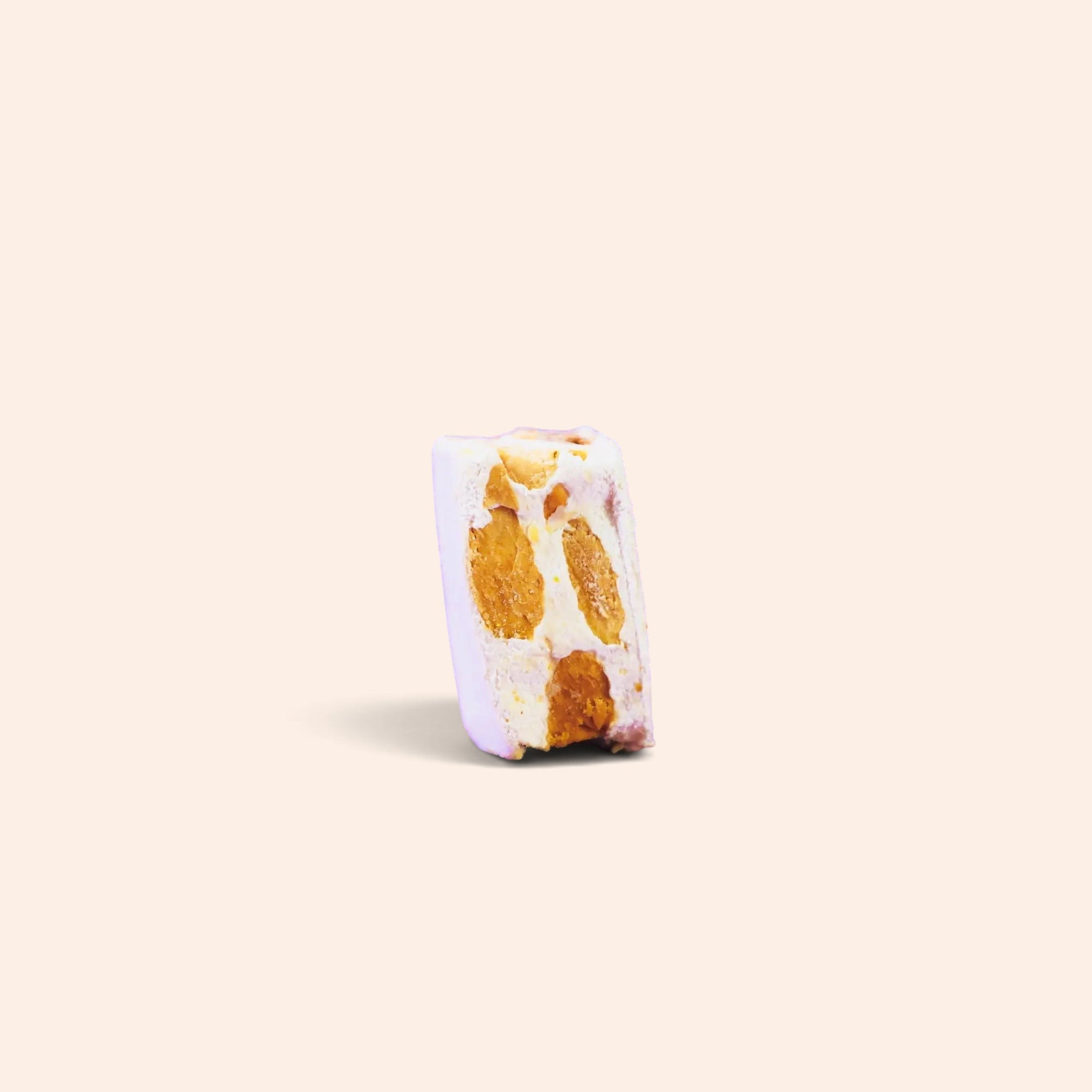 Morceau de nougat à la vanille Maison Fruidoraix avec amandes entières sur fond crème